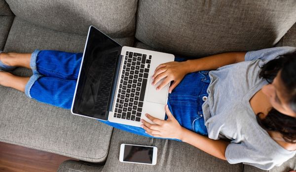 一个女人斜靠在沙发上的电脑前研究因伯格林的变化