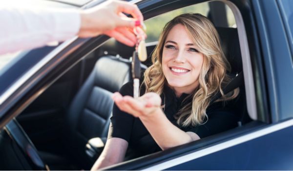一个女人在一辆车后把钥匙使用汽车分类广告在荷兰购买它