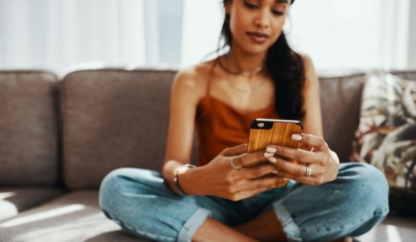 W Oman坐在沙发上玩约会软件，作为在荷兰认识人的例子