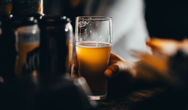 酒吧桌上一只手拿着精酿啤酒